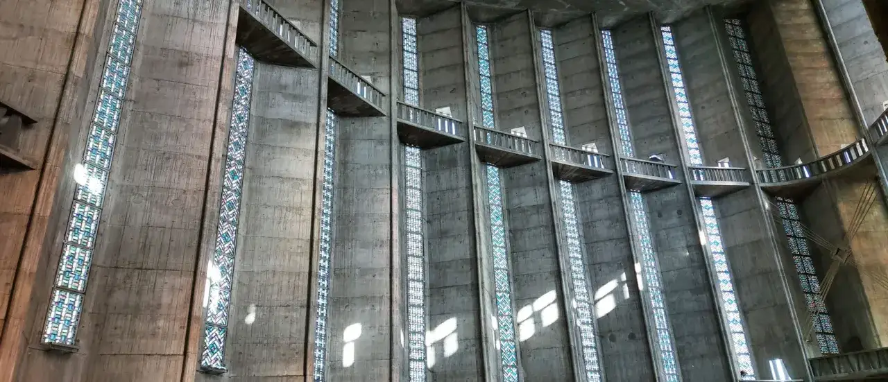 Intérieur de la cathédrale de Royan, avec ses hauts vitraux colorés et ses balcons en béton.