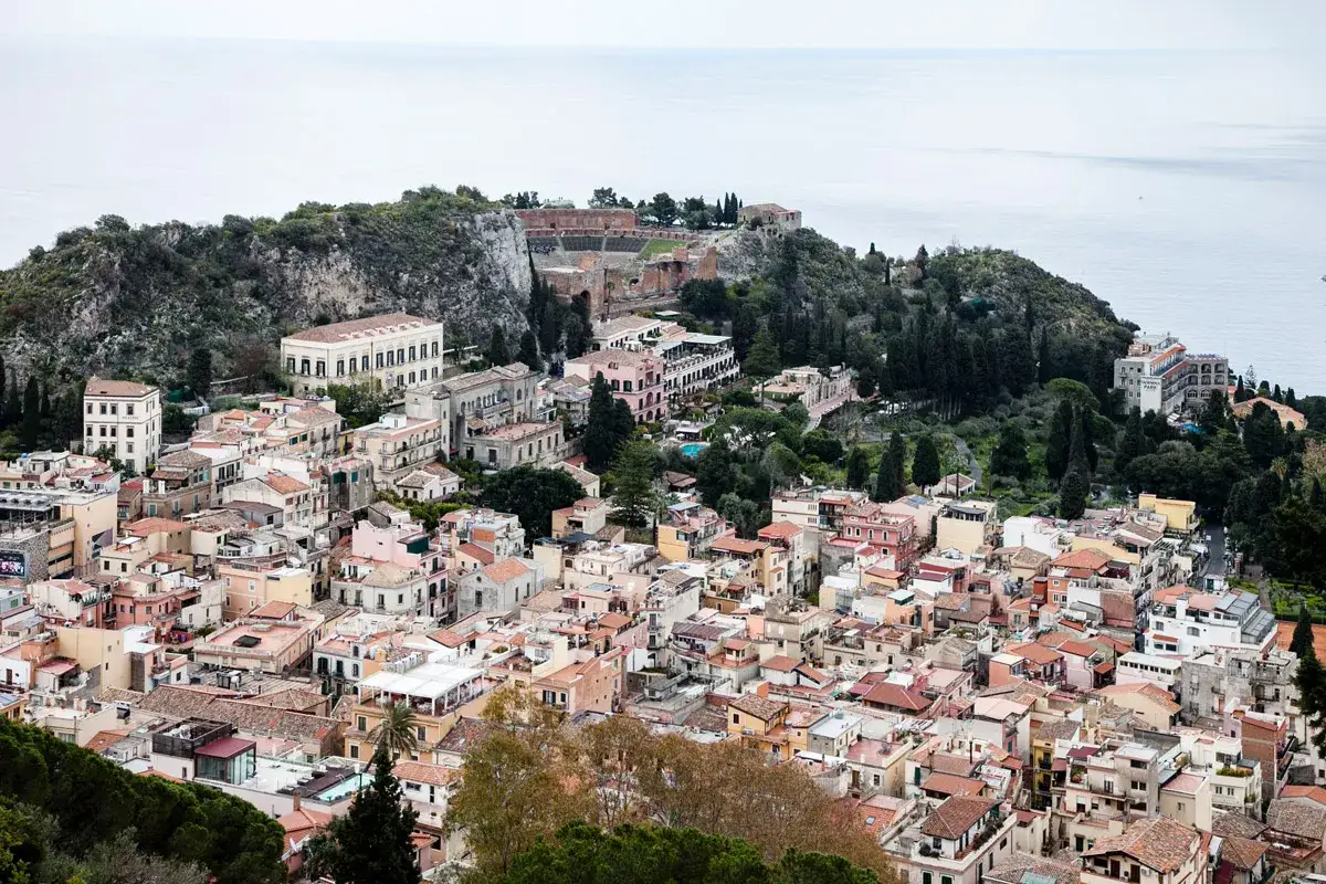 Vista panoramica di Taormina, con il teatro antico in cima alla collina. Perfetto per un weekend in Sicilia.
