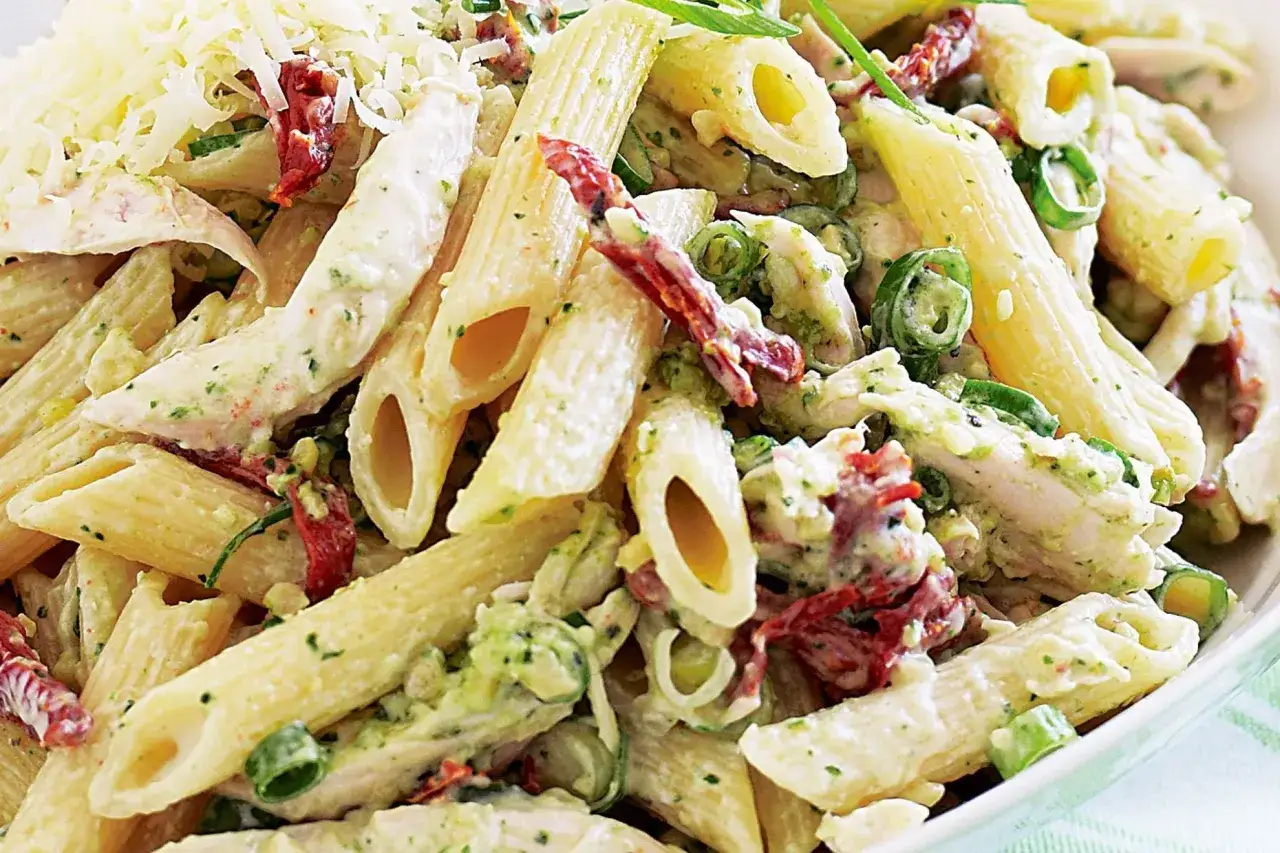 Penne z kurczakiem w sosie pesto, z suszonymi pomidorami i zieloną cebulką, posypane parmezanem. Pyszne danie, które zachwyci każdego miłośnika makaronu.