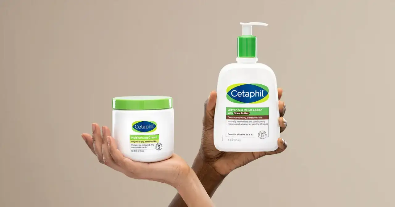 Tv&aring; h&auml;nder h&aring;ller upp Cetaphil-produkter. En hand h&aring;ller en burk med &aring;terfuktande kr&auml;m, den andra en flaska med body lotion i ansiktet.