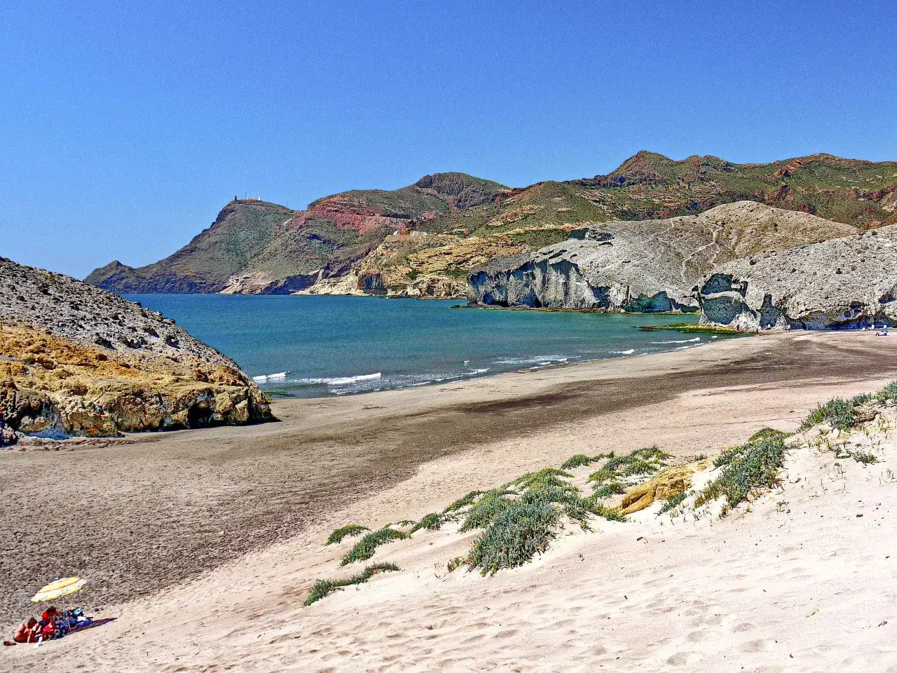 Traumhafter Almer&iacute;a Urlaub: Sandstrand, t&uuml;rkisfarbenes Meer und bizarre Felsformationen unter blauem Himmel. Ein perfekter Ort zum Entspannen.
