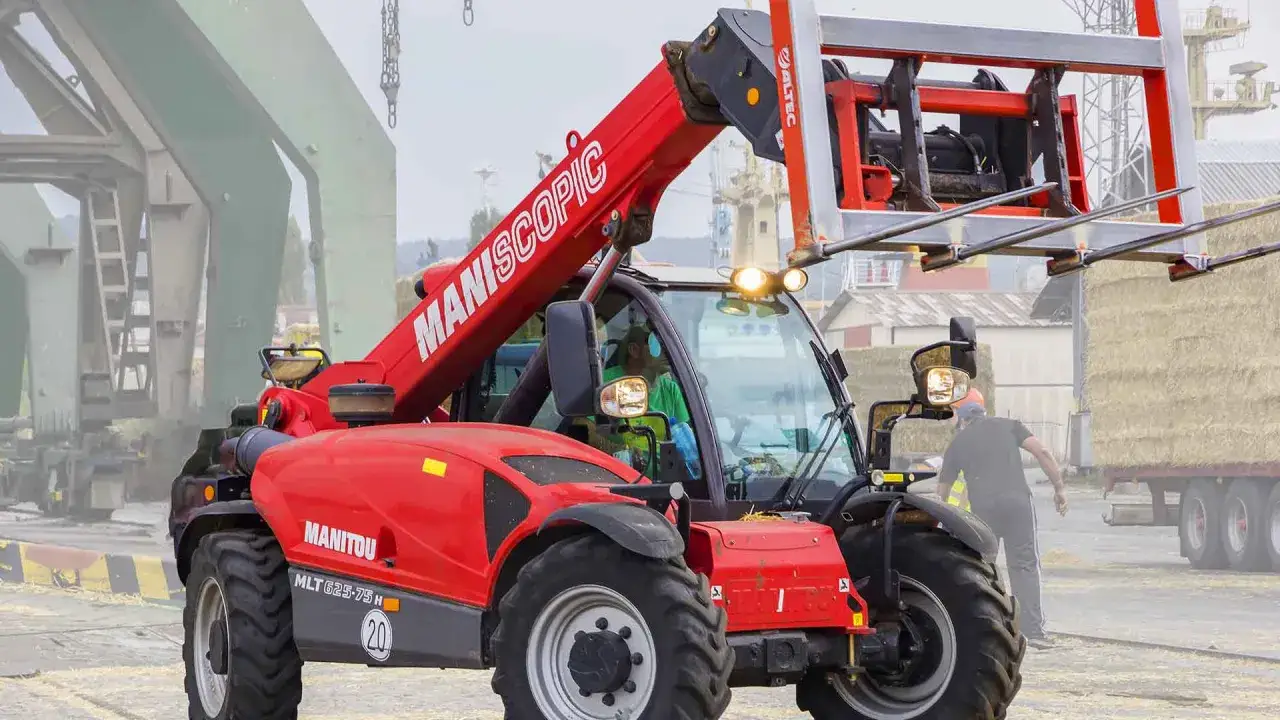 Czerwony ładowacz teleskopowy Manitou MLT 625-75 H z podniesionym wysięgnikiem, gotowy do pracy. Posiadanie uprawnień na manitou to klucz do efektywnego ładowania.