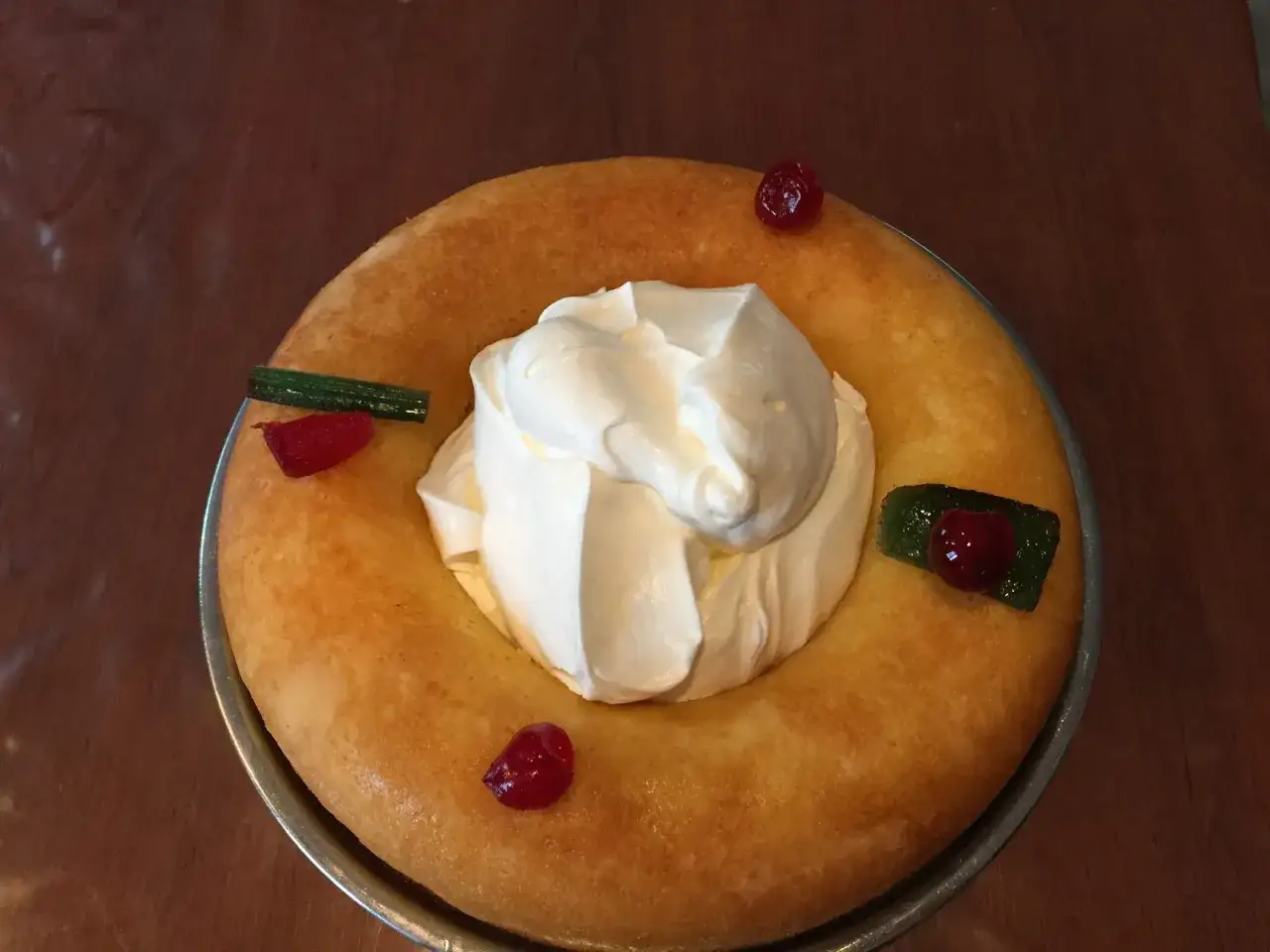 Un baba au rhum généreux, couronné de chantilly et décoré de fruits confits. Une invitation à la gourmandise.