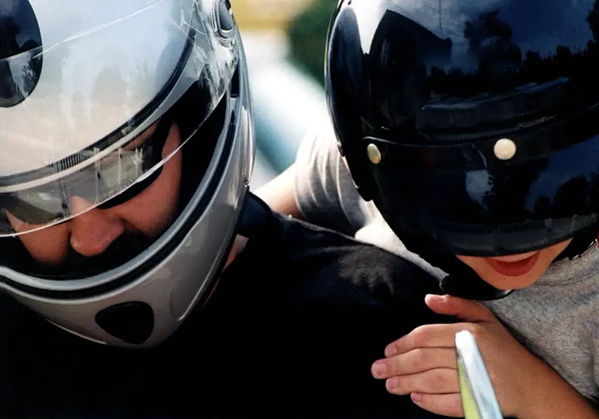 Dos personas con cascos, una plateada y otra negra. ¿A qué edad puede ir un niño en moto?