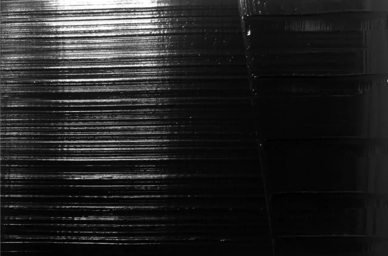 Texture de peinture noir absolu, avec des lignes horizontales fines et des blocs plus épais sur la droite.