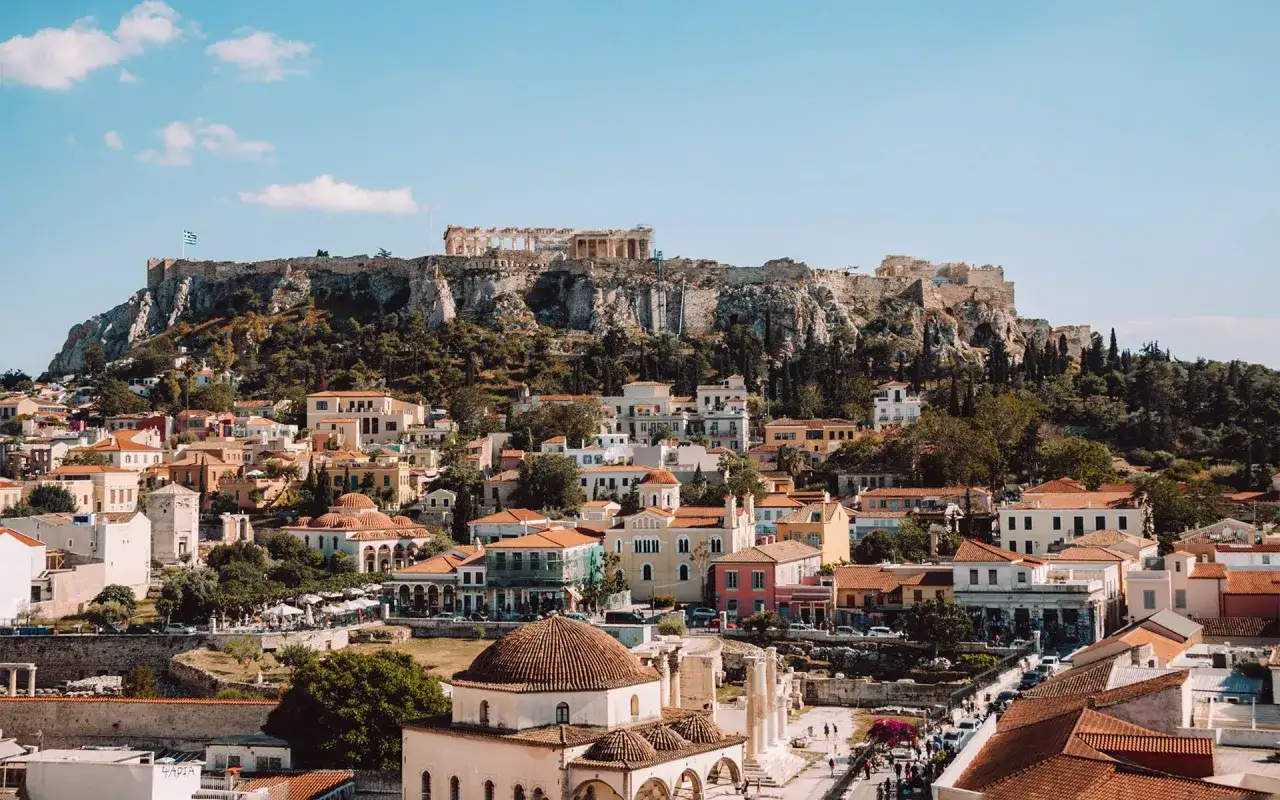 Blick auf die Akropolis und die bunten H&auml;user von Athen. Ein perfekter Ort f&uuml;r Athen Sightseeing, mit antiken Ruinen und lebendigem Stadtleben.
