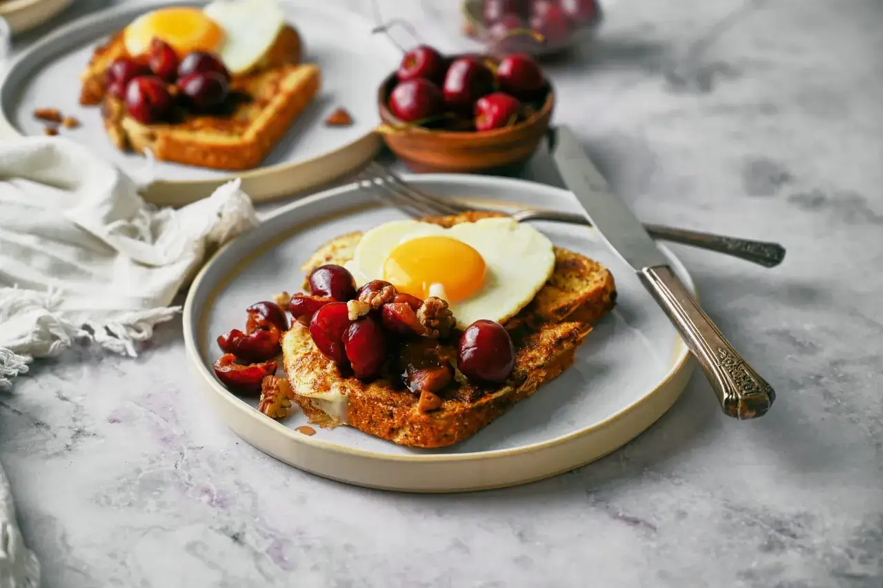 Herzhaftes French Toast Protein mit Spiegelei, Kirschen und N&uuml;ssen. Ein perfekter Start in den Tag!