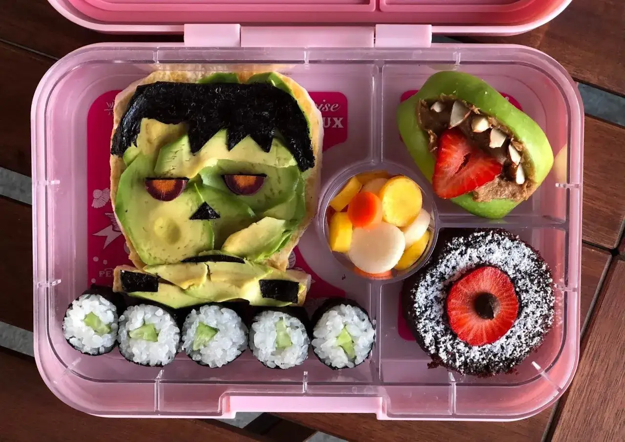Fun vegan bento ideas! Frankenstein avocado toast, apple monster, sushi, fruit salad, and a chocolate cake.