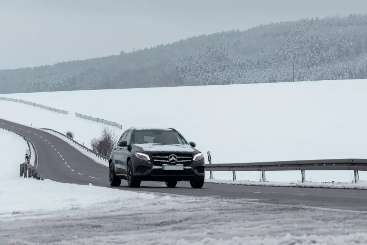 Czarny Mercedes GLE pokonuje zimową drogę. Jego wymiary pozwalają na pewne manewrowanie nawet w trudnych warunkach.