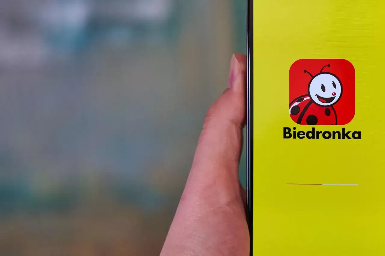 Uruchamiam moja biedronka aplikacja. Na ekranie telefonu widnieje logo z uśmiechniętą biedronką i nazwa sklepu.