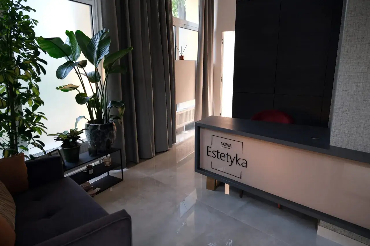 Nowa estetyka Wrocław: nowoczesne wnętrze salonu piękności z roślinami i wygodną sofą.