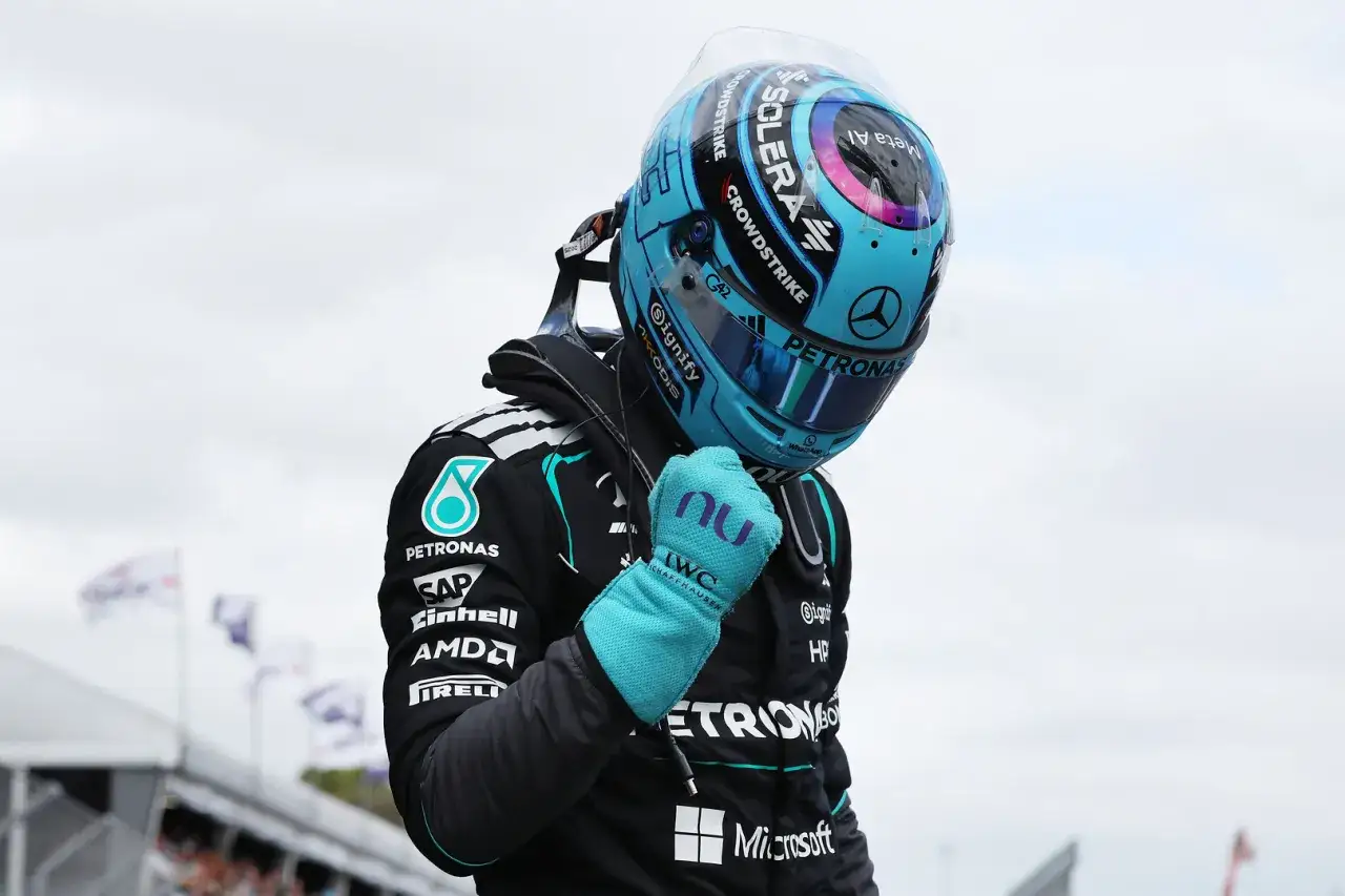 Piloto de F&oacute;rmula 1, con casco azul y guante turquesa, pu&ntilde;o cerrado. Podr&iacute;a ser Kimi Antonelli celebrando una victoria.