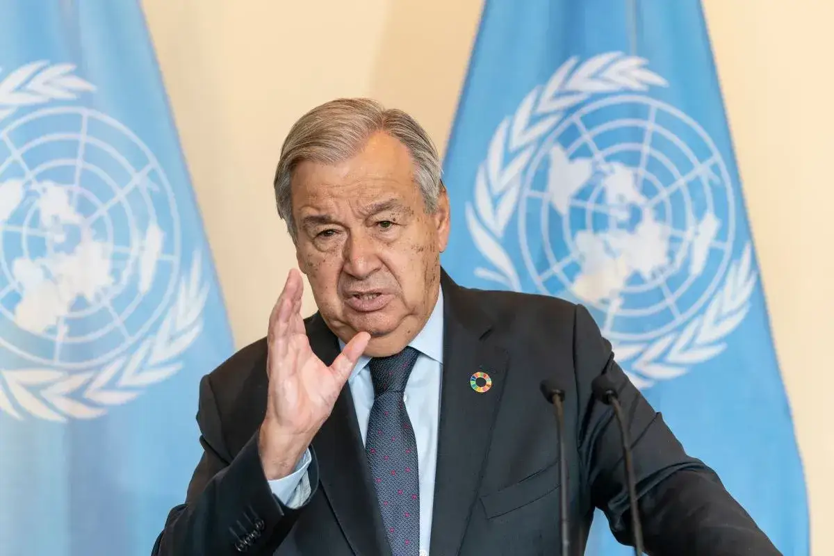 Sekretarz generalny ONZ, António Guterres, przemawia na tle flag ONZ.