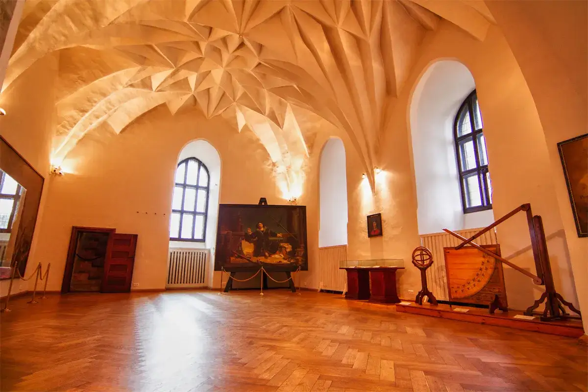 Wnętrze zamku w Olsztynie z malowidłem i zabytkowymi instrumentami.