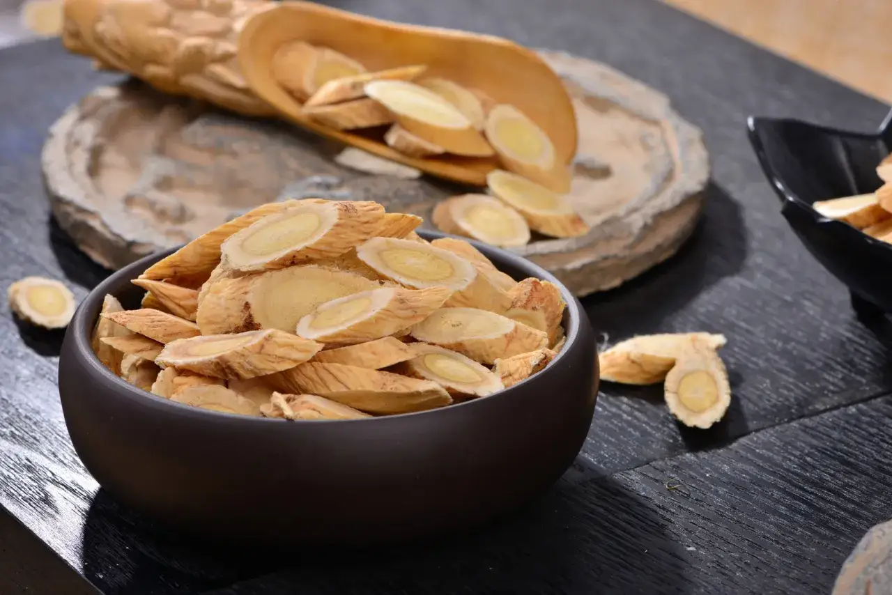 Tranches d'astragale s&eacute;ch&eacute; dans un bol, &eacute;voquant ses nombreux bienfaits pour la sant&eacute;.