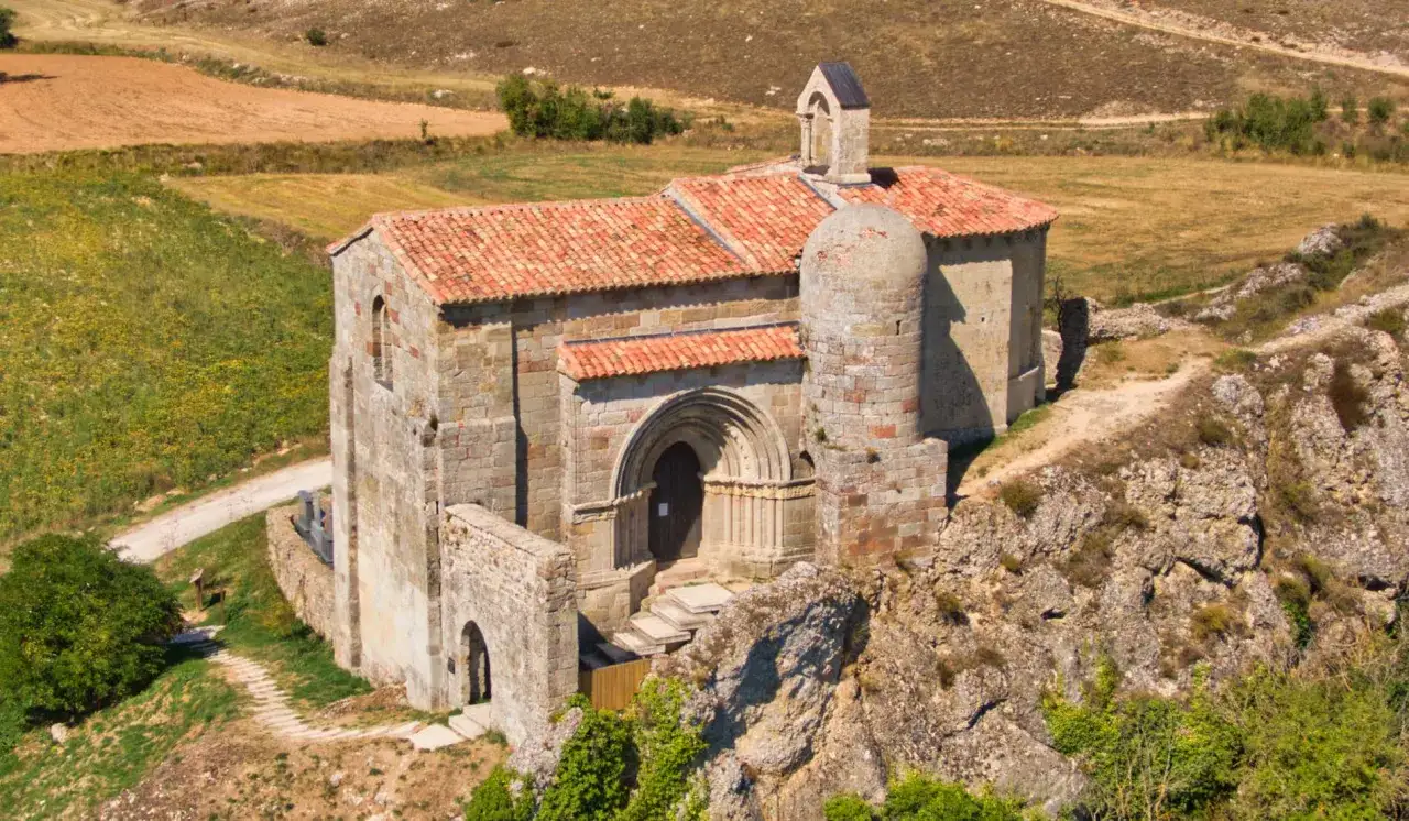 Ermita de San Vicente del Valle, joya del rom&aacute;nico palentino, se alza sobre un pe&ntilde;asco rodeada de campos.