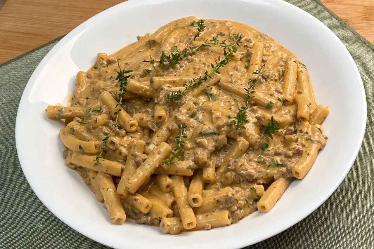 Un piatto di pasta alla Montecarlo cremosa, con macinato e erbe fresche, guarnita con rametti di timo.