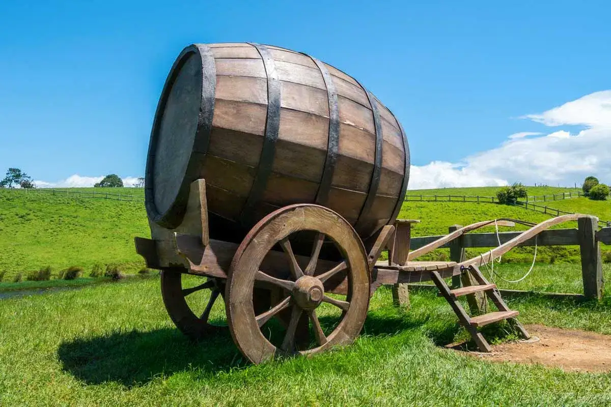 Carro con botte di legno su un prato verde. Le botti, ricche di tannini, sono usate per invecchiare vino e liquori.