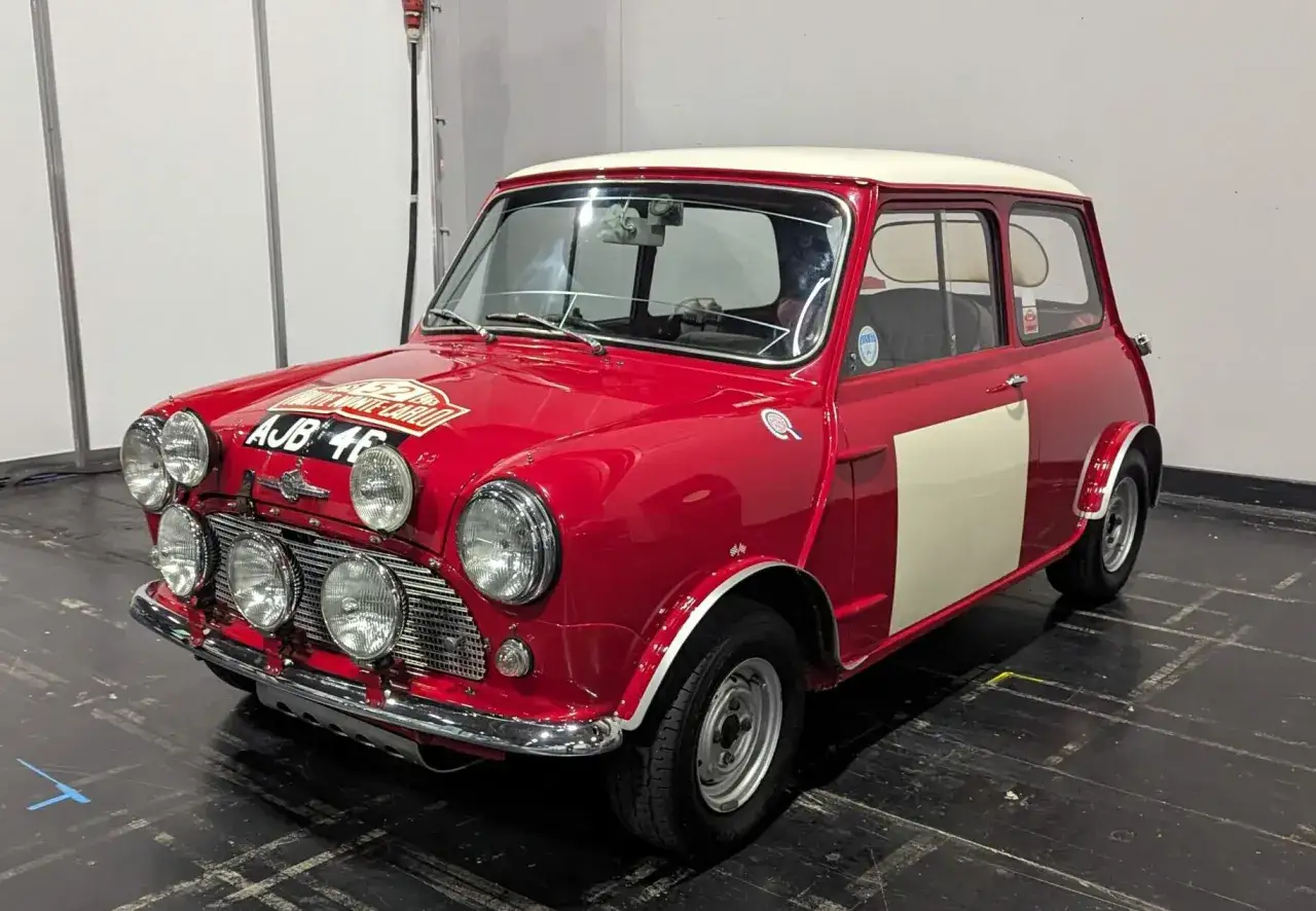 Röd rally-inspirerad mini med rallydekaler och extraljus. Ett ikoniskt mini bilmärke som minner om klassiska tävlingar.