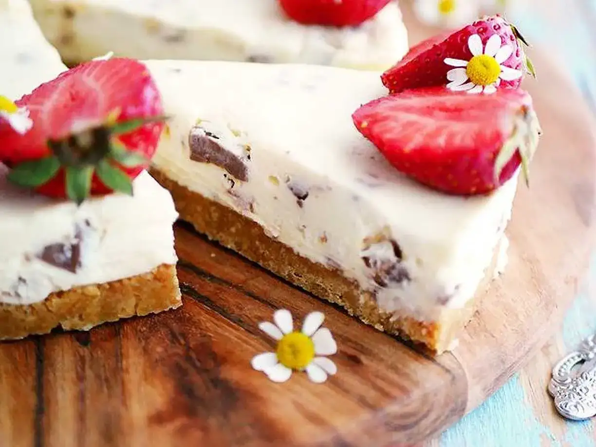 En kr&auml;mig daim cheesecake med jordgubbar och sm&aring; blommor. Perfekt f&ouml;r en sommardessert.