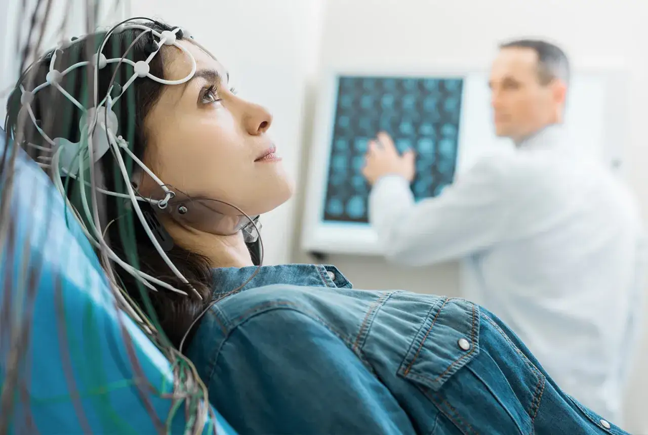 Donna con elettrodi sulla testa per esami neurologici, forse per studiare le memoria a breve termine cause. Medico analizza immagini cerebrali.