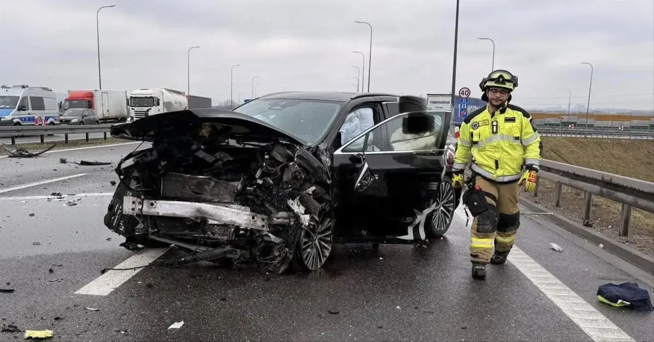 Szczegóły wypadku luksusowego auta znanego sportowca. Zniszczony przód pojazdu, strażak w żółtej kurtce przygląda się zdarzeniu.