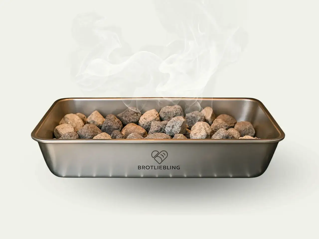 Metallschale mit Steinen, aus denen Dampf aufsteigt. Perfekt zum **mit Dampf backen** für knuspriges Brot.
