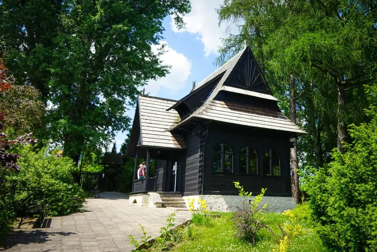 Drewniany dworek w Nałęczowie, idealne miejsce, by zobaczyć, co warto zobaczyć w Nałęczowie. Otoczony zielenią, zaprasza do zwiedzania.