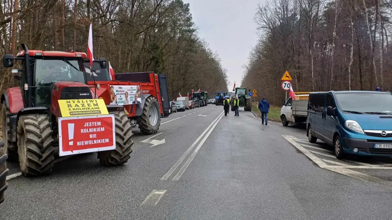 Rolnicy protestują przeciwko Zielonemu Ładowi. Traktory blokują drogę, a na nich transparenty: 