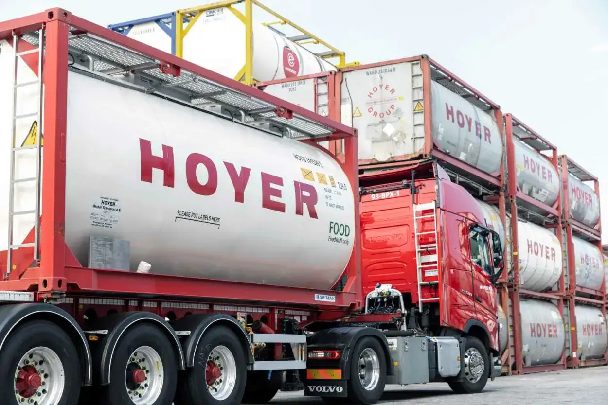 Ein roter LKW mit einem gro&szlig;en wei&szlig;en Tankauflieger mit der Aufschrift 