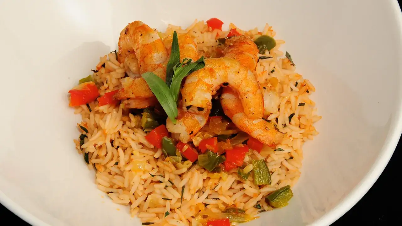 Arroz con gambas y verduras, un plato colorido con camarones jugosos y trozos de pimiento rojo y verde.