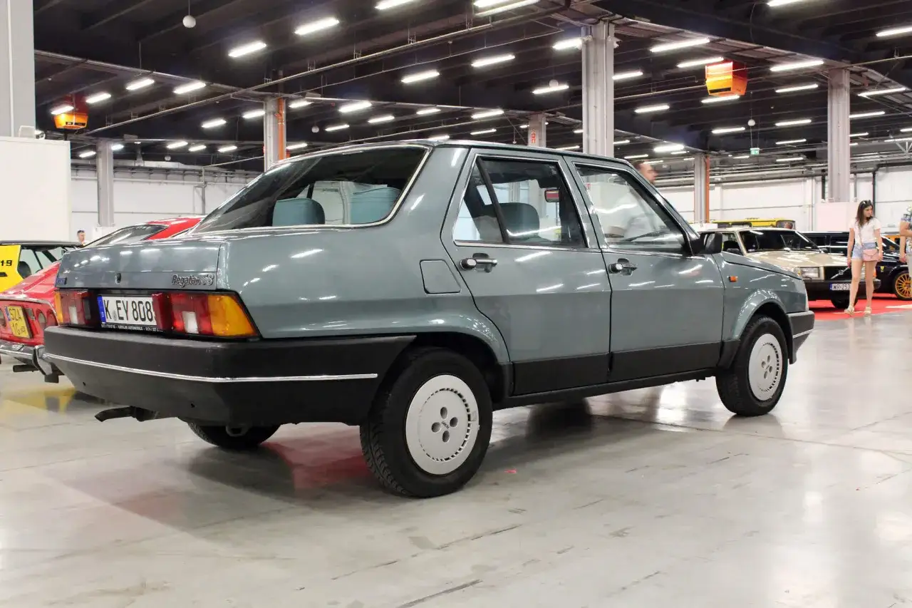 Szary Fiat Regata, klasyk z lat 80., prezentowany na wystawie motoryzacyjnej.