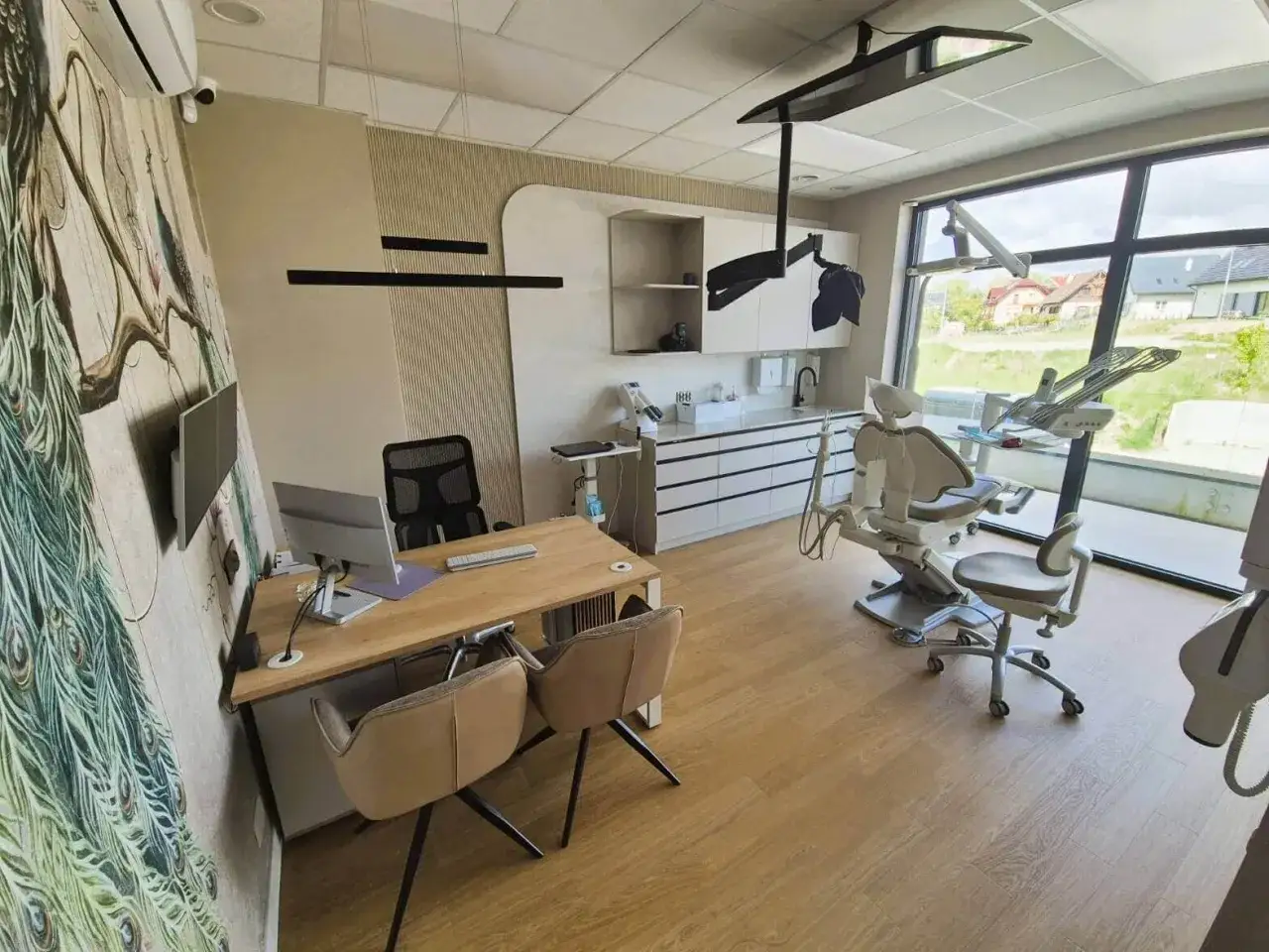 Nowoczesny gabinet stomatologiczny z fotelem dentystycznym i biurkiem.