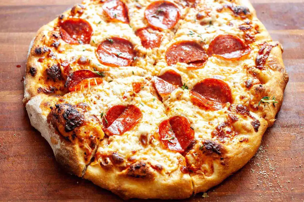 Chrupiąca pizza pepperoni z ciągnącym się serem i ziołami, idealna na wieczór filmowy.