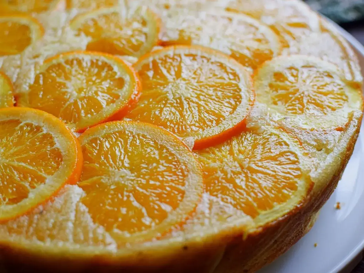 Bizcocho de naranja y yogur, decorado con rodajas de naranja fresca. Un postre casero, jugoso y aromático.