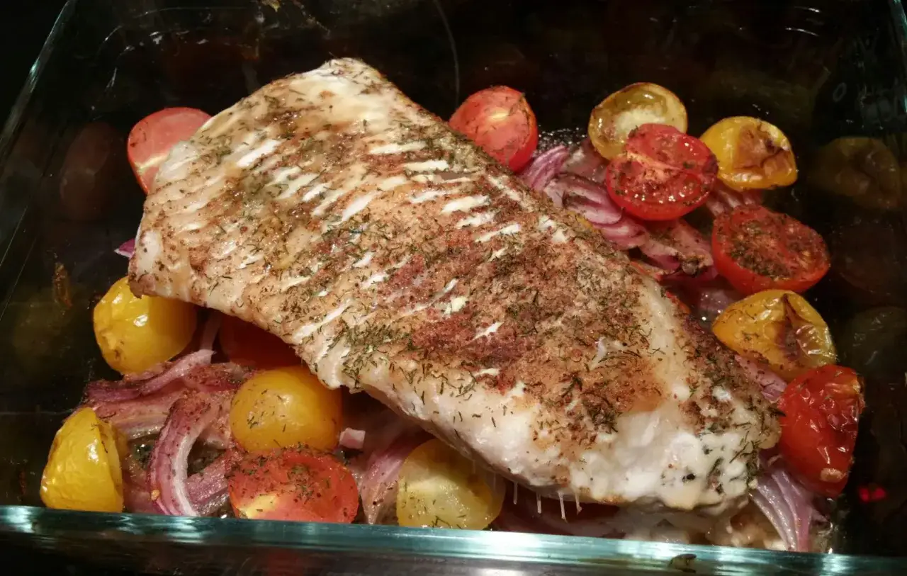 D&eacute;licieux filet de loup au four, parfum&eacute; au vin blanc, accompagn&eacute; de tomates cerises et d'oignons rouges r&ocirc;tis.