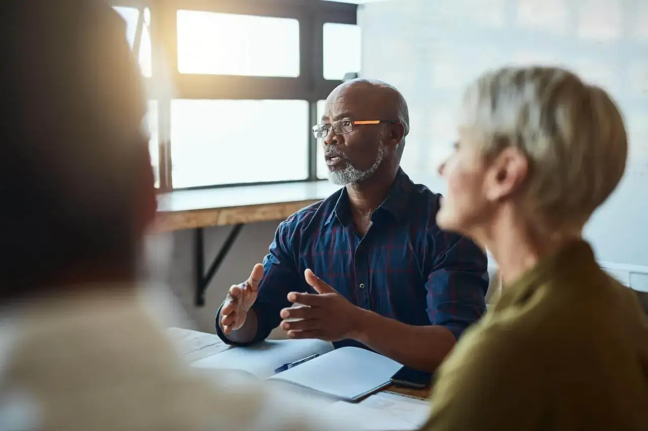 An executive life coach guides a team meeting, fostering collaboration and strategic thinking.