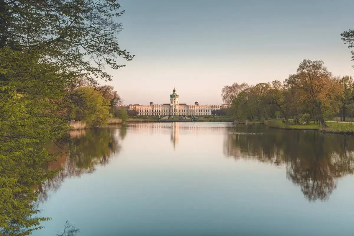 Schloss Charlottenburg spiegelt sich im Wasser. Ein sch&ouml;ner Ort zum Wandern in Berlin.