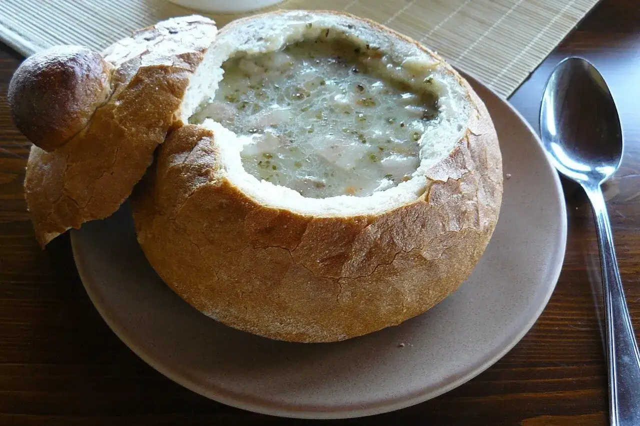 Pyszny żur podany w chlebie, z łyżką obok, gotowy do jedzenia.