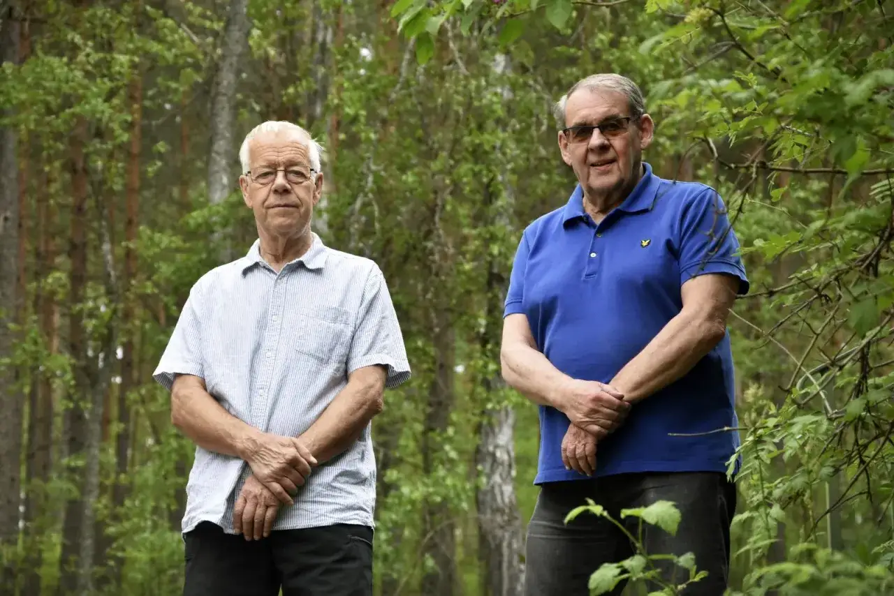 Tv&aring; &auml;ldre m&auml;n st&aring;r i en lummig skogsmilj&ouml; i stadsparken Falun.