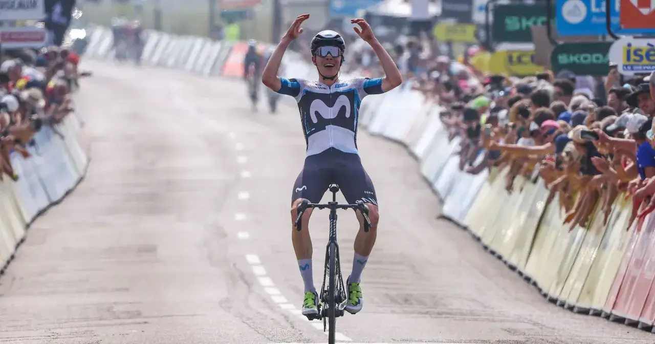 Kolarz Movistar Team triumfuje na mecie Criterium du Dauphiné, wznosząc ręce w geście radości.