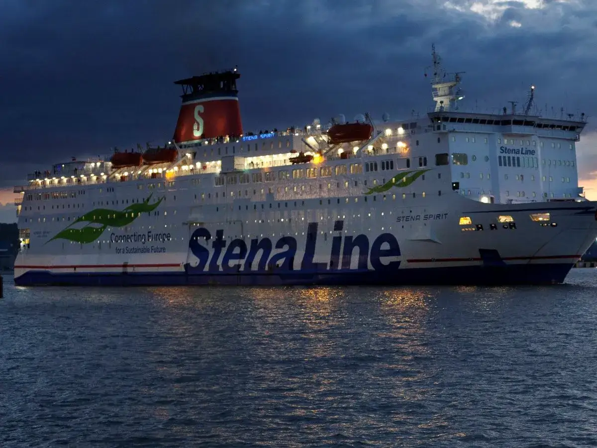 Stena Line prom wypływa nocą, oświetlony, z widoczną nazwą i zielonymi liśćmi.