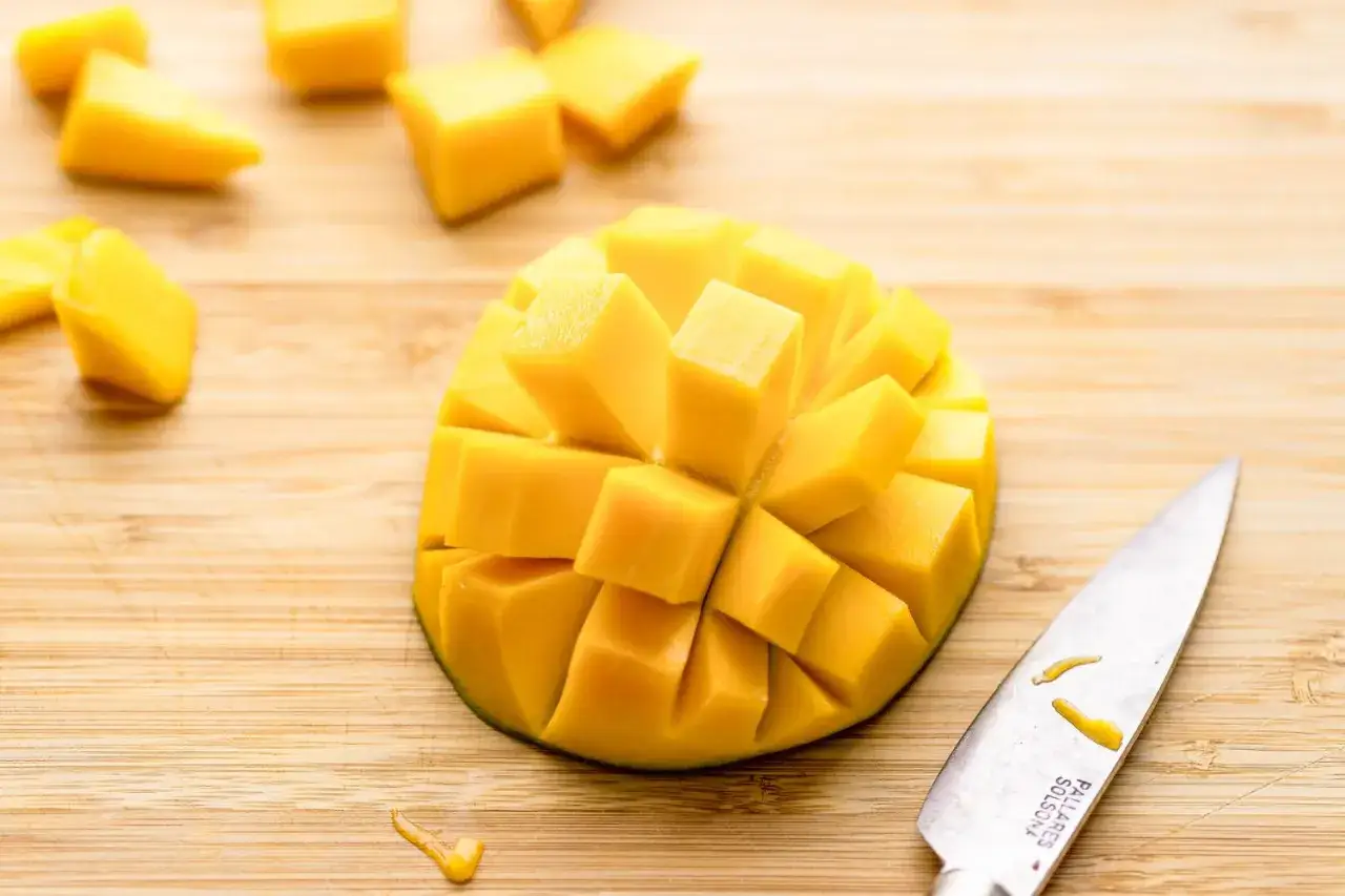 Pokrojone w kostkę mango na desce, gotowe do spożycia. Odkryj jego liczne mango właściwości!
