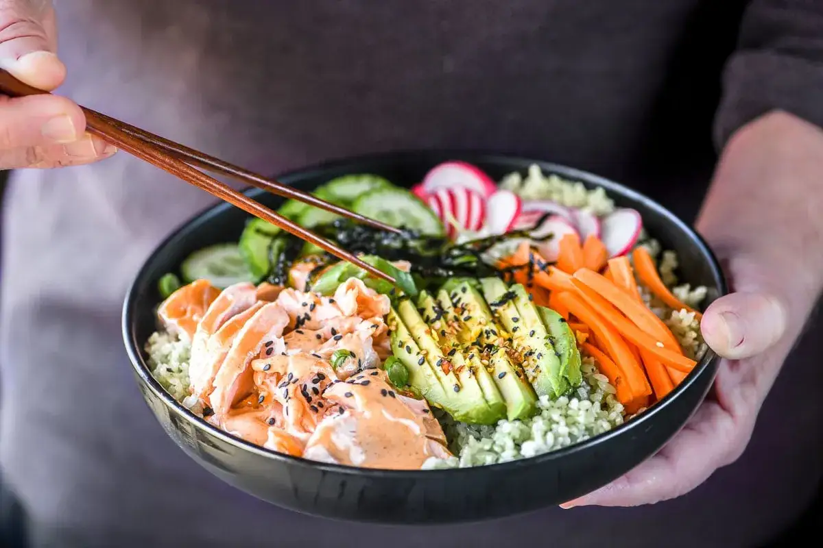 En poke bowl med lax, avokado, gurka, morötter och rädisor. Perfekt för ett snabbt och hälsosamt wasabi recept.