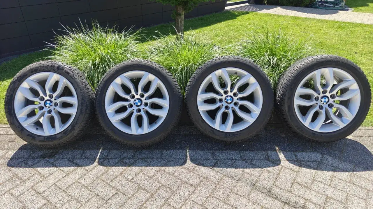 Cztery felgi z oponami zimowymi, idealne dla BMW X7 M60i, gotowe na każdą drogę.