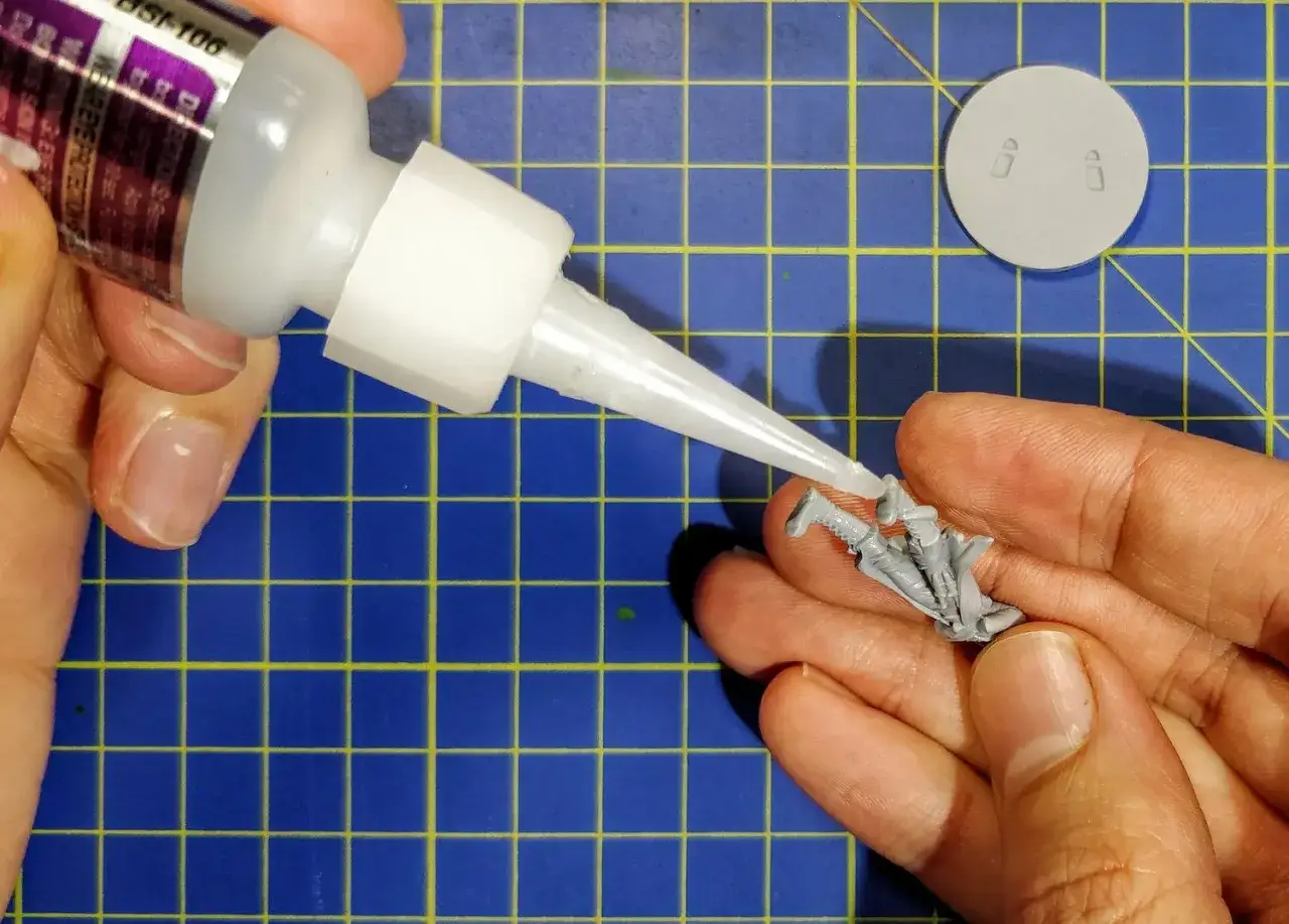 Applying the best super glue for resin models to a miniature figure.