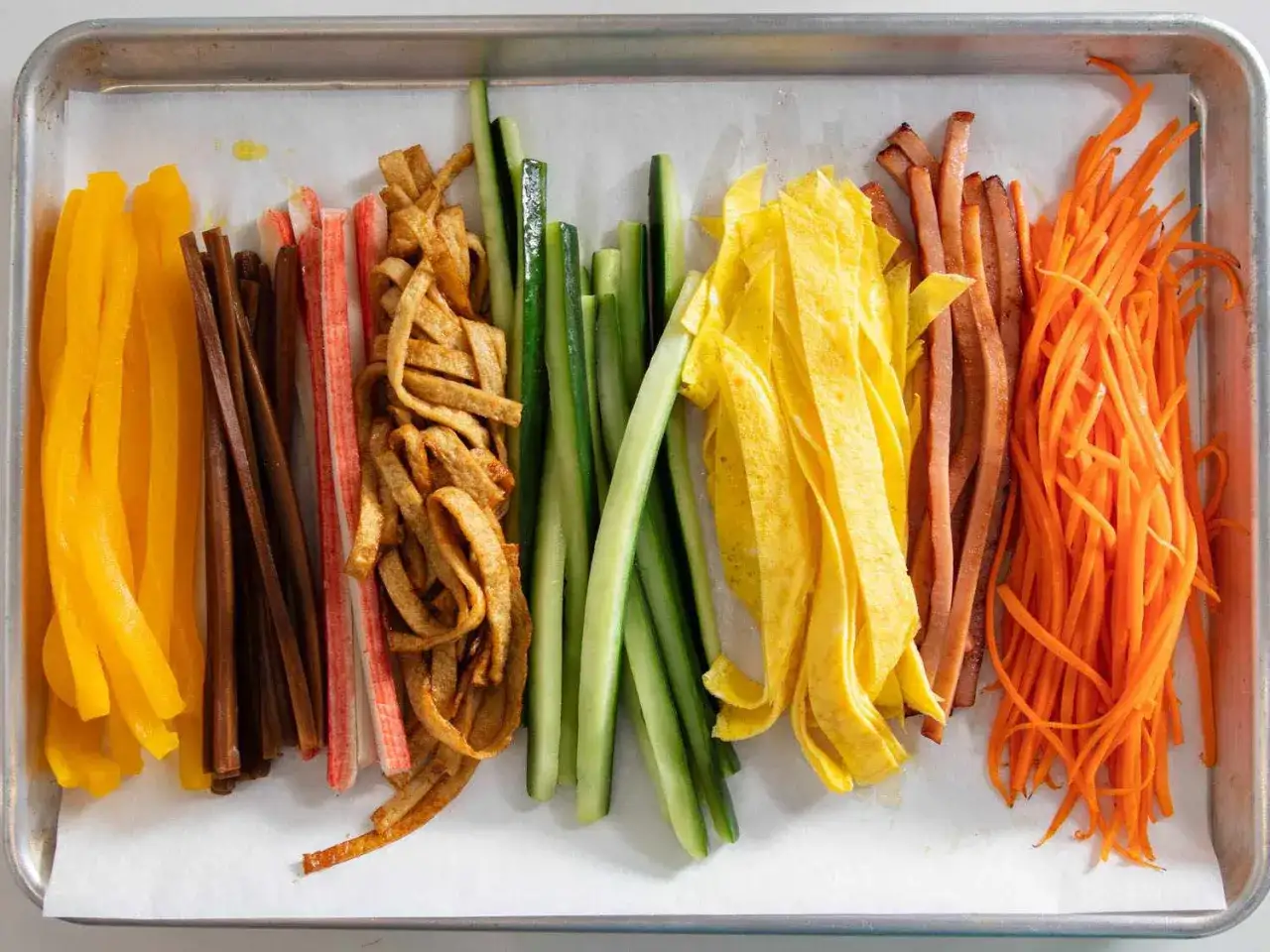 Bunte Zutaten f&uuml;r Kimbap: Paprika, Karotten, Gurken, Ei, Krabbenst&auml;bchen und Tofu. So wird Kimbap gemacht!