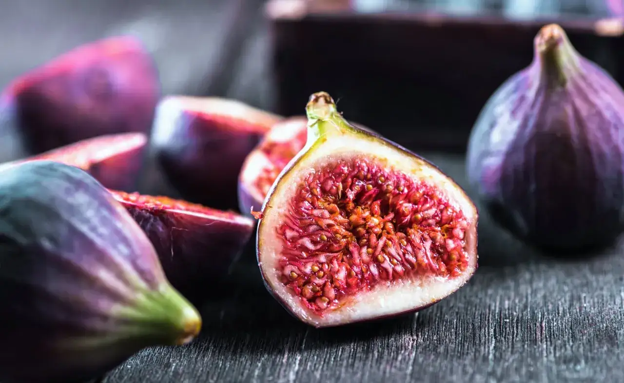 Saftige Feigen, aufgeschnitten und im Ganzen, laden dazu ein, zu entdecken, wie süß und aromatisch sie schmecken.