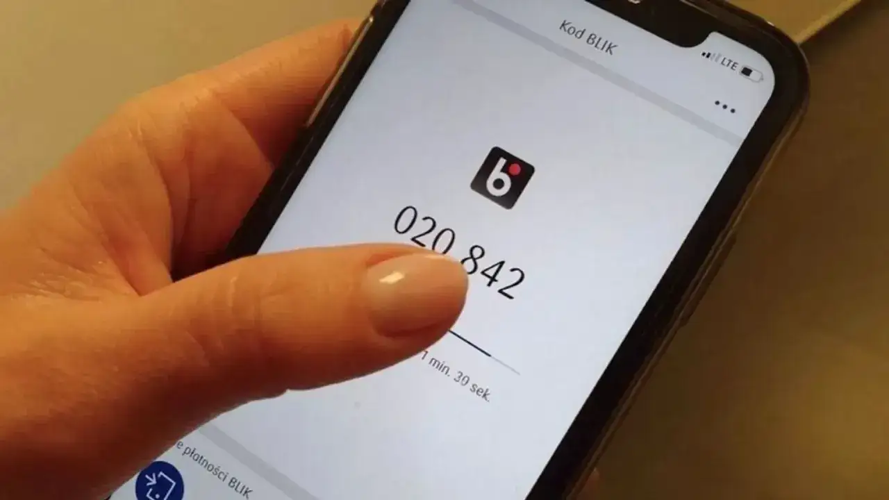 Palec wskazujący dotyka ekranu telefonu z kodem BLIK 020 842. To szybki sposób na przelew od znajomego, bez obaw o podatek od przelewu.
