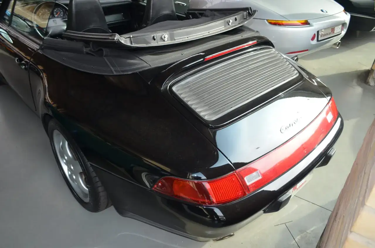 Czarny kabriolet Porsche 993 Carrera z otwartym dachem.
